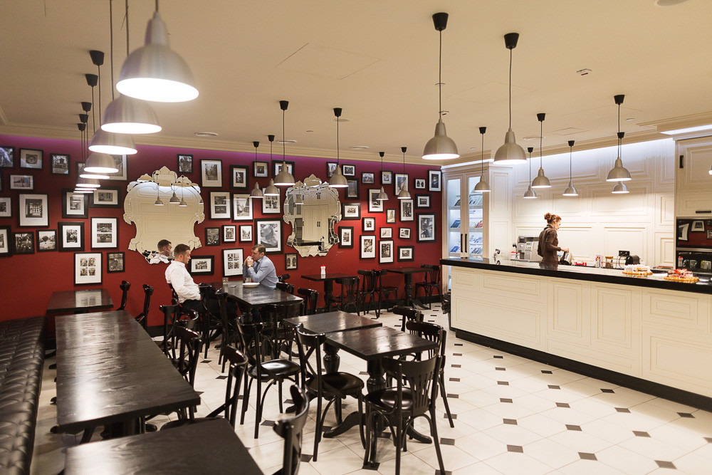Кафе для сотрудников выполнено в стиле французского бистро с черно-белыми фотографиями, зеркалами и барной стойкой
