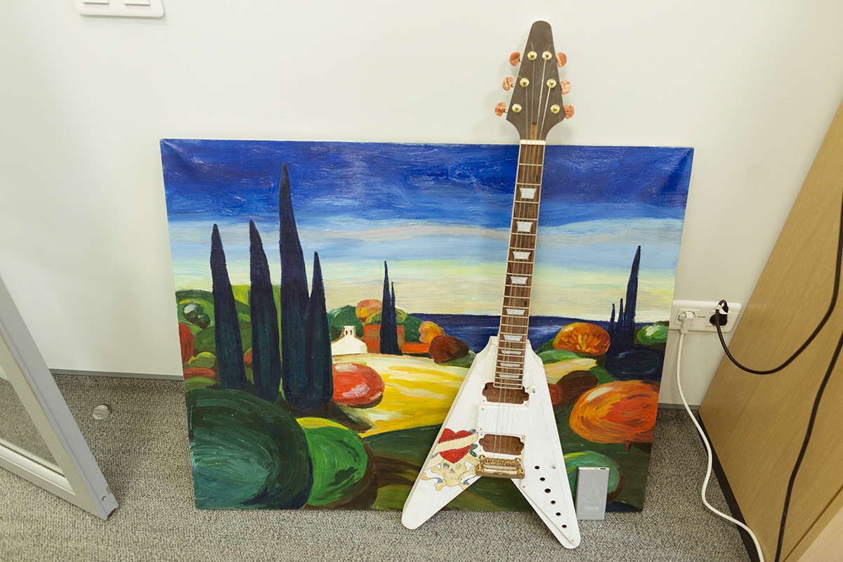 Кабинет одного из бренд-директоров украшают картины, которые он сам пишет, и его любимая гитара.